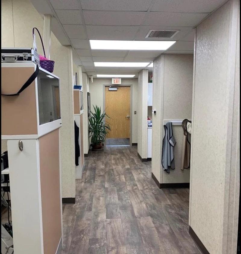 A clean and modern hallway inside Shawnee Dentistry and Braces, featuring wood flooring and dental exam rooms.